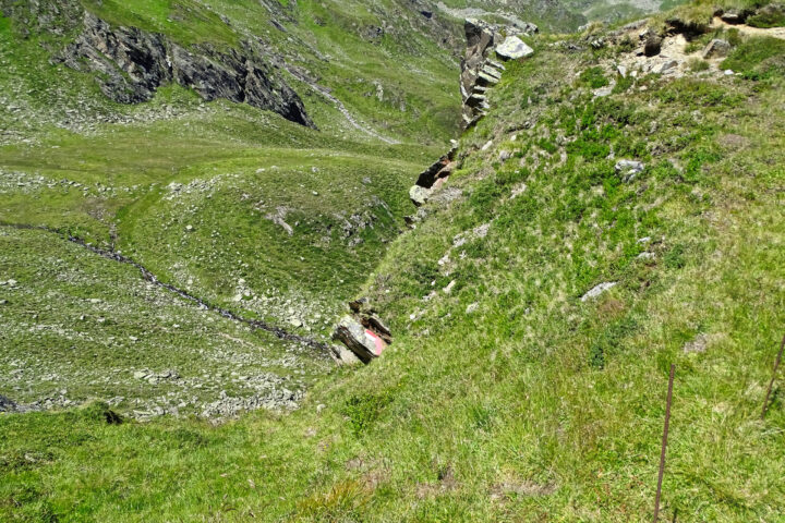 Markierung des Abstieges vom Sattel über der Sturzmahd in den Kessel mit der Weide am Schmelzwasserbach. Dahinter sehen wir in unser Zieljoch, umringt von schroffen Felsrücken und viel Geröll 1. Foto: Thomas Obermair