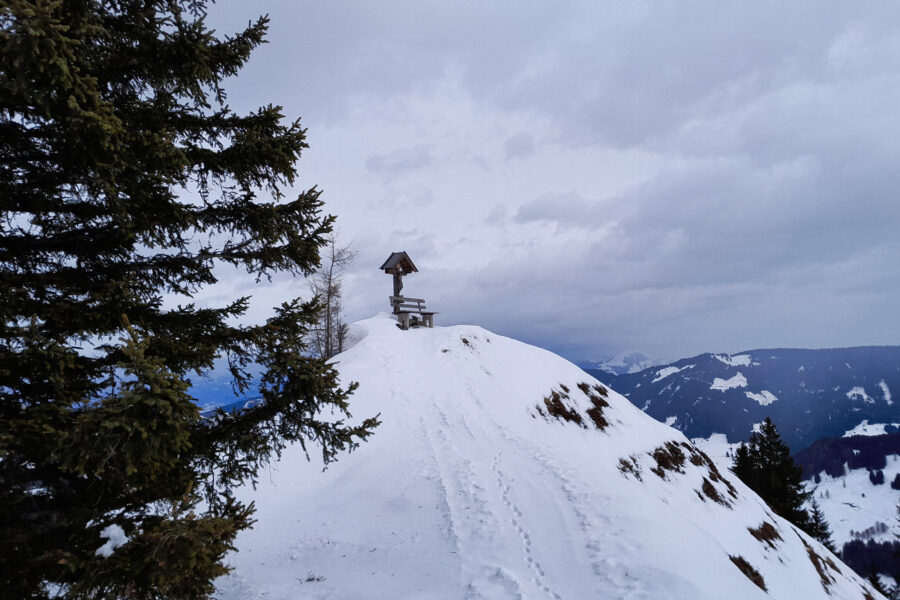 Kurz vor dem letzten Anstieg entlang des Grats ziert dieses Marterl eine kleine Erhebung. Im Hintergrund sieht man schon die Vorboten der herannahenden Wetterfront. Foto: Protect Our Winters Austria (POW AT)